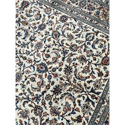 Persian Kashan ivory ground rug, decorated with curled leafy branches and palmettes, the border with scrolling design decorated with further palmettes, within floral pattern guard stripes