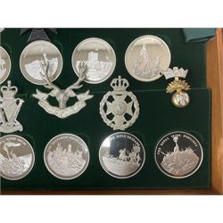 Great British Regiments, 1977, set of fifty two frosted silver medals by the Birmingham Mint, each bearing the name of a regiment with a depiction of an action on the obverse and further details on the reverse, all hallmarked Birmingham Mint, assay offices and dates; together with 52 base metal copy cap badges for each regiment, all housed and mounted on two trays and contained within a wooden presentation case, with brass plaque and fittings, lock and key, with a certificate of authenticity 