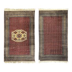 Pakistani Kashan hand-knotted rug with a central medallion and intricate geometric floral patterns, set against a red field and framed by a multi-band border (156 x 94cm); Pakistani Kashan rug with a repeating floral motif across the red field, enclosed by a detailed geometric border in complementary tones (162 x 95cm)