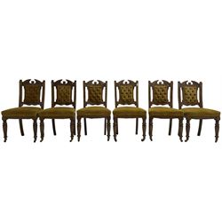 Set of six late Victorian carved oak dining chairs, buttoned back and sprung seat upholstered in mustard yellow velvet, on turned front supports with castors