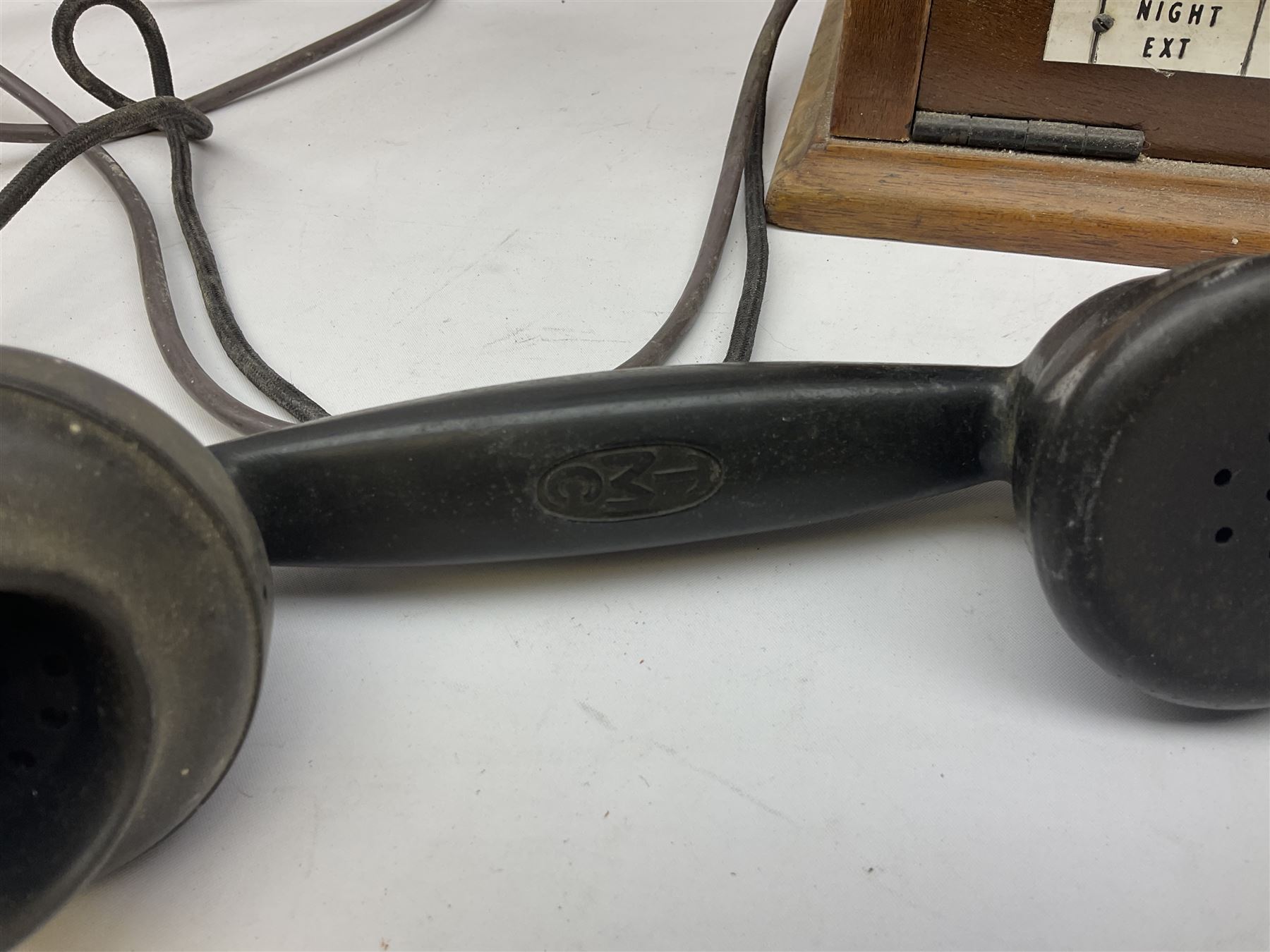 Early-mid 20th century internal telephone system, comprising exchange box with attached TMC rotary telephone and dictograph with Bakelite handset and support upon stained wood case, and 1960s black Bakelite telephone model 312L with G.P.O sticker beneath, largest H30.5cm W36.5cm D30cm