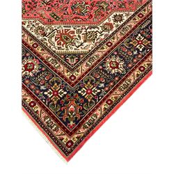 North West Persian pink ground Tabriz carpet, central indigo ground medallion surrounded by stylised plant motifs and trailing foliage, the main border with overall floral design within guard stripes 