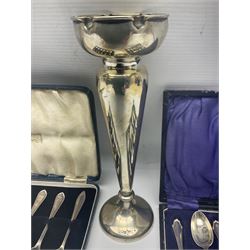 Early 20th century silver trumpet vase, upon knopped stem and circular filled foot, hallmarked Walker and Hall, Sheffield 1912, together with two cased sets of silver coffee spoons, all hallmarked