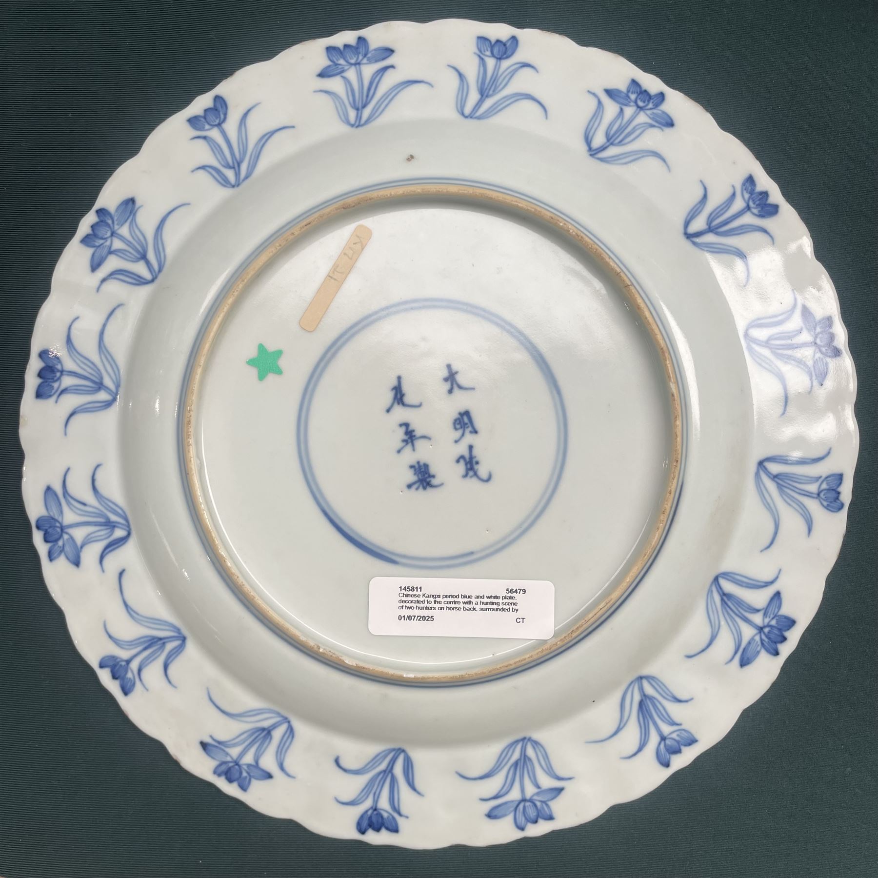 Chinese Kangxi style blue and white plate, decorated to the centre with a hunting scene  of two hunters on horse back, surrounded by a foliate boarder, with with six character double ring mark beneath
