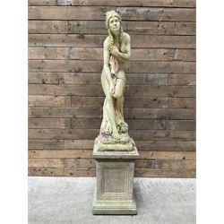 Cast stone garden figure of a bathing lady, raised on square plinth