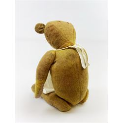 Early 20th century English teddy bear c1920 with wood wool filled body, jointed swivel head with glass eyes and horizontal stitched nose and mouth, jointed limbs and inoperative growler mechanism H23