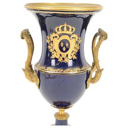 19th century Sevres style ormolu mounted porcelain twin handled urn, the body decorated with a gilt crowned crest of three fleur de lis against a cobalt ground, with spurious Sevres mark beneath, H26cm
