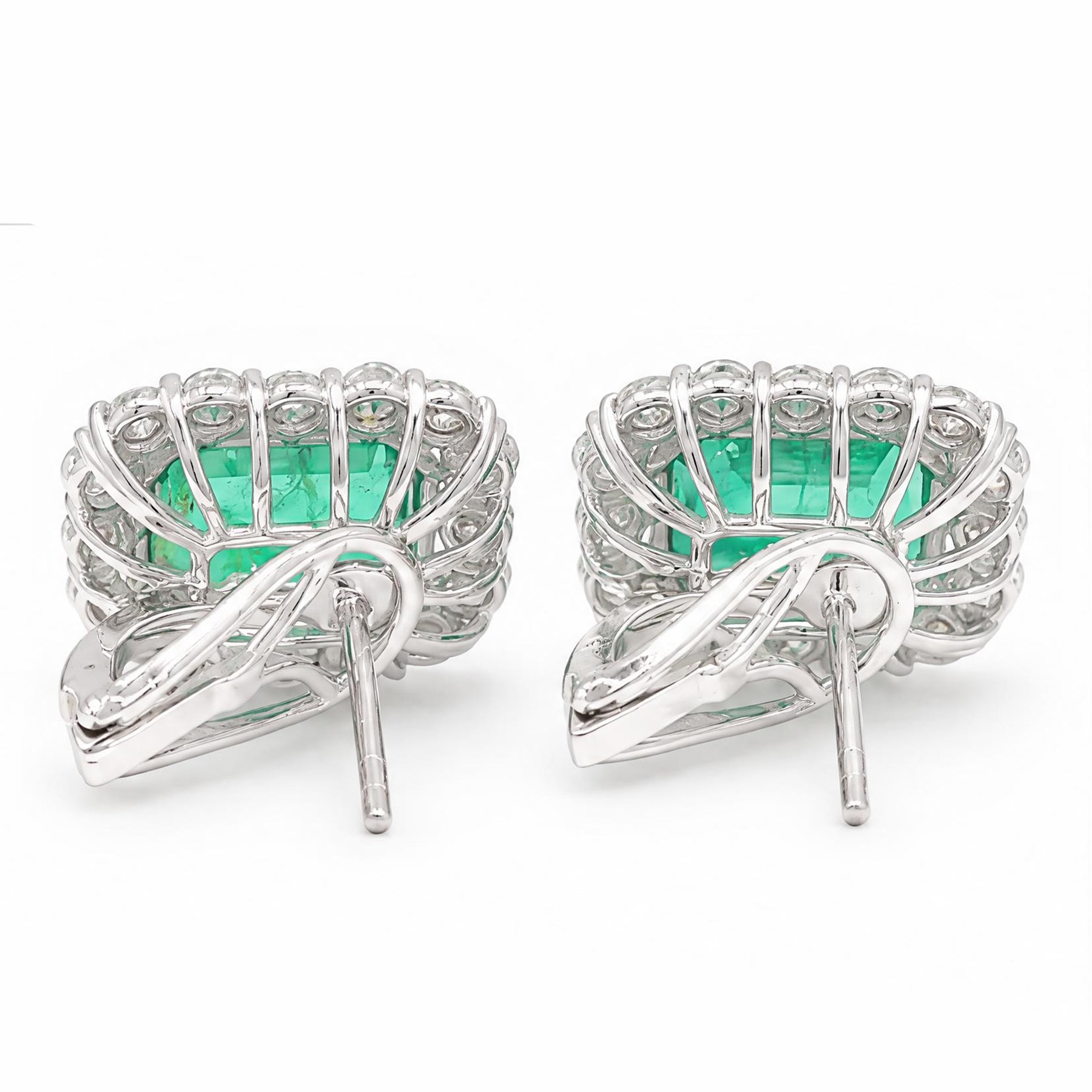 Pair of 18ct white gold emerald and diamond cluster earrings, each stud set with a single octagonal cut emerald and surrounded by sixteen round brilliant cut diamonds, stamped 750, total emerald weight approx 6.90 carat, total diamond weight approx 1.90 carat