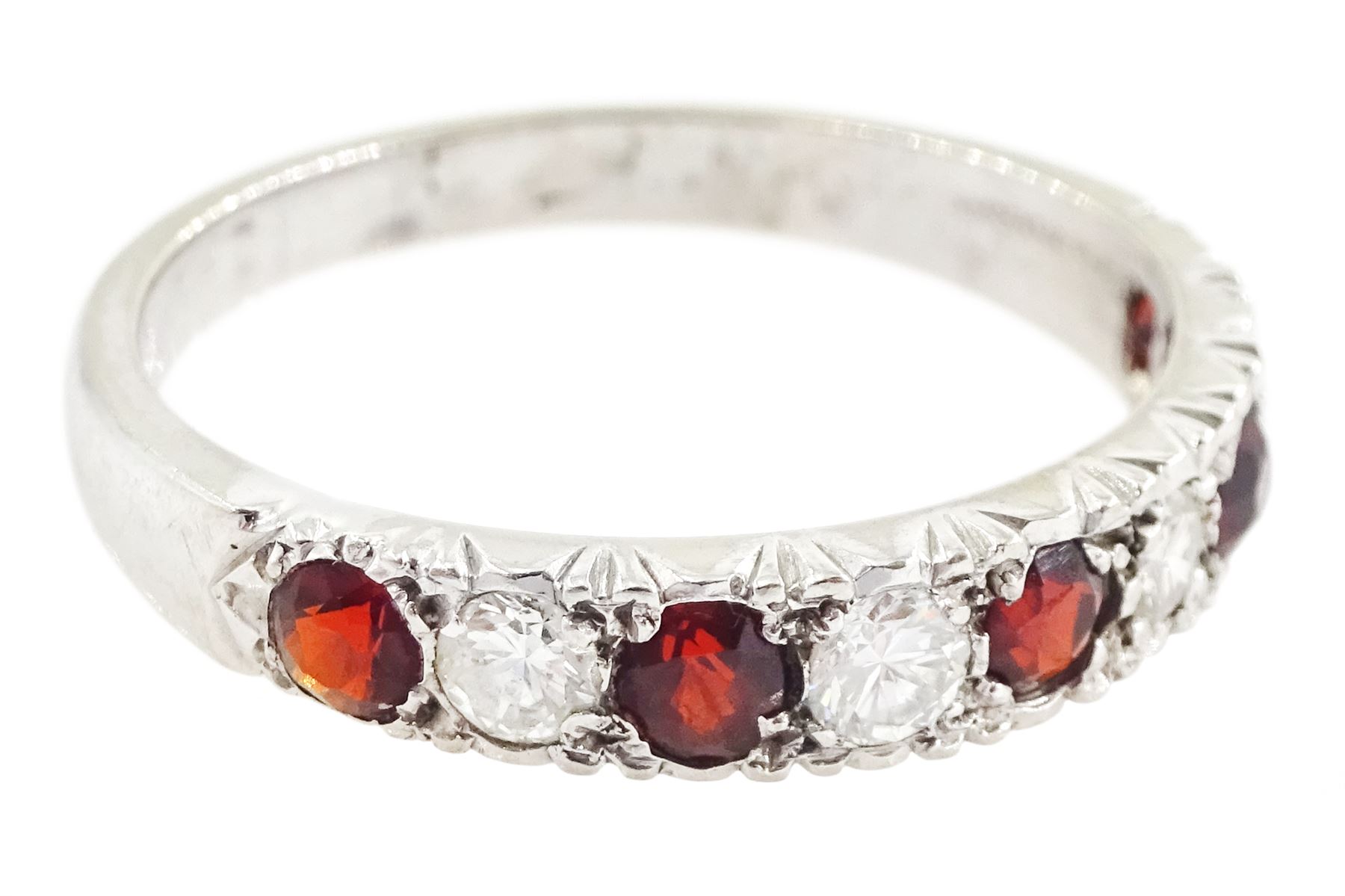 White gold garnet and diamond half eternity ring, nine alternating round brilliant cut diamonds and round cut garnets, stamped 18ct, total diamond weight approx 0.30 carat