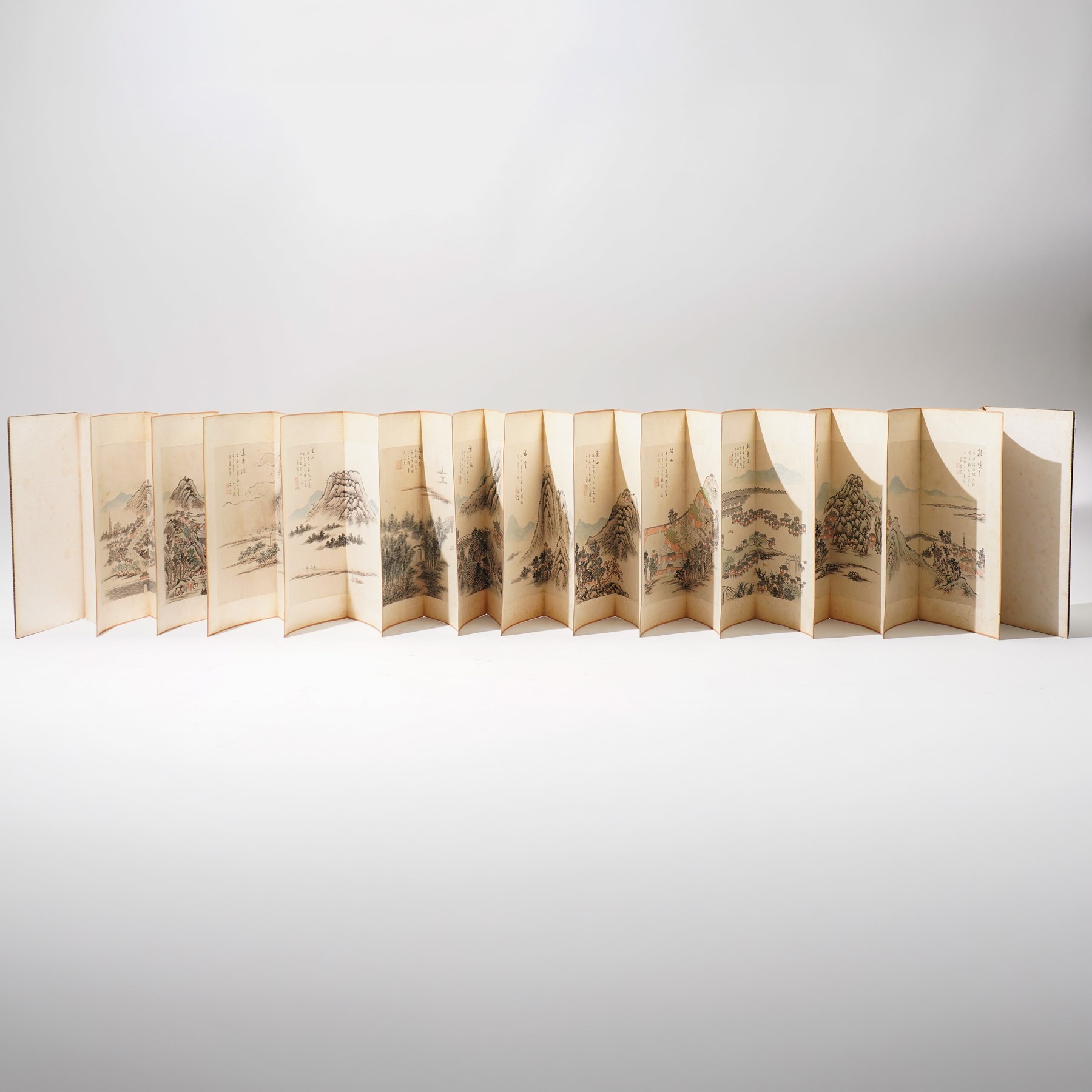 Chinese fold out book, comprising 12 hand-coloured woodblock landscapes each bearing inscription and artists seal  