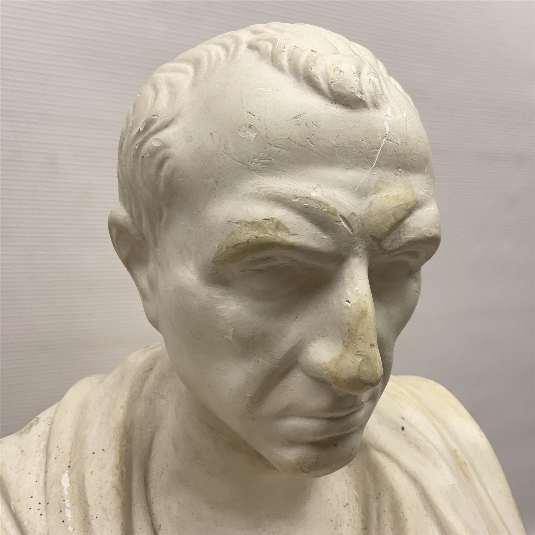 Composite bust of a classical figure of the Roman Julius Caesar being raised on a socle plinth, H62cm