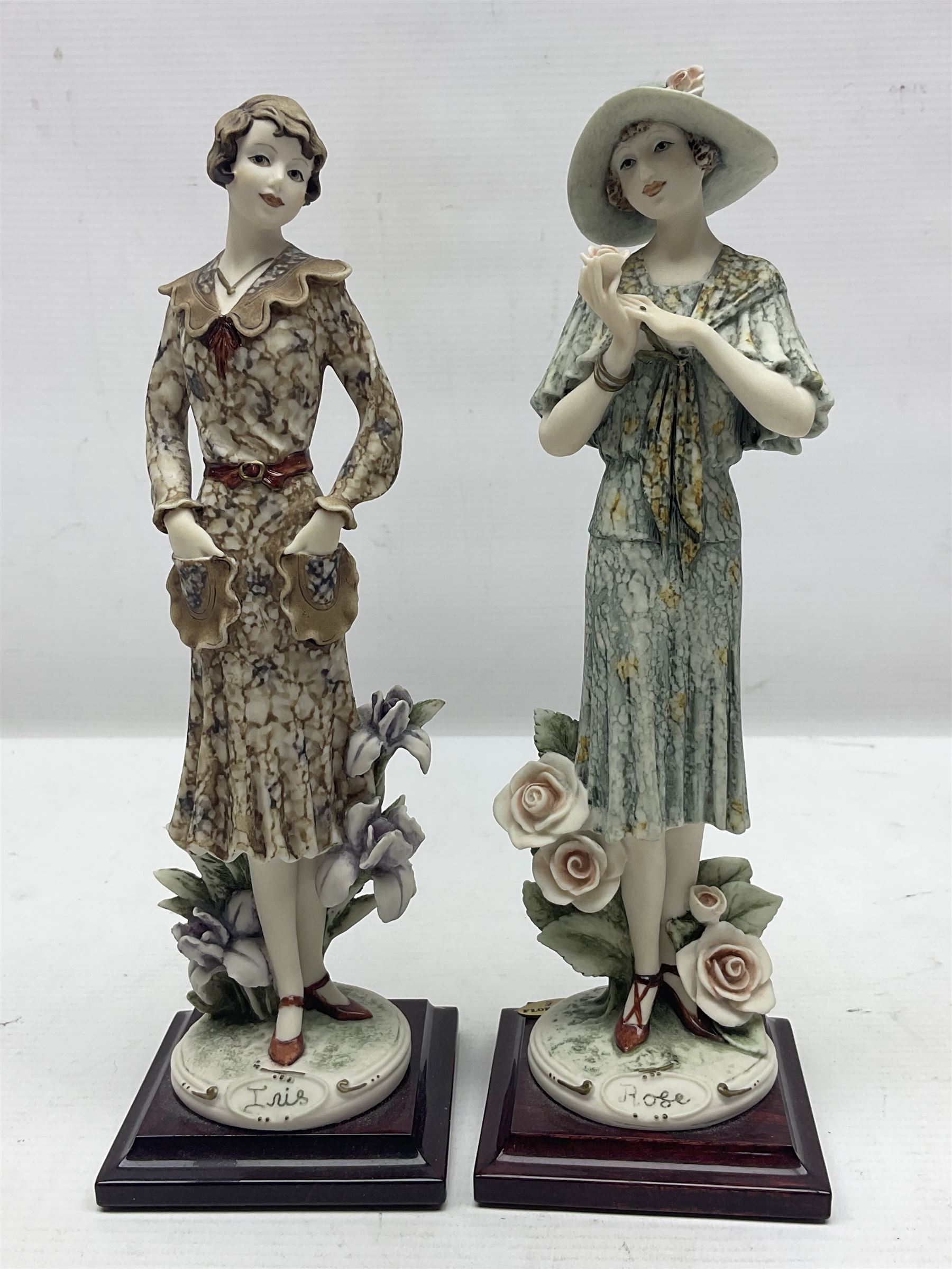 Set of four Giuseppe Armani Florence figures, Iris, Rose, Lily and Daisy, each modelled as ladies in 1920s dress amongst flowers, with names and signature inscribed and upon mahogany base, H23cm