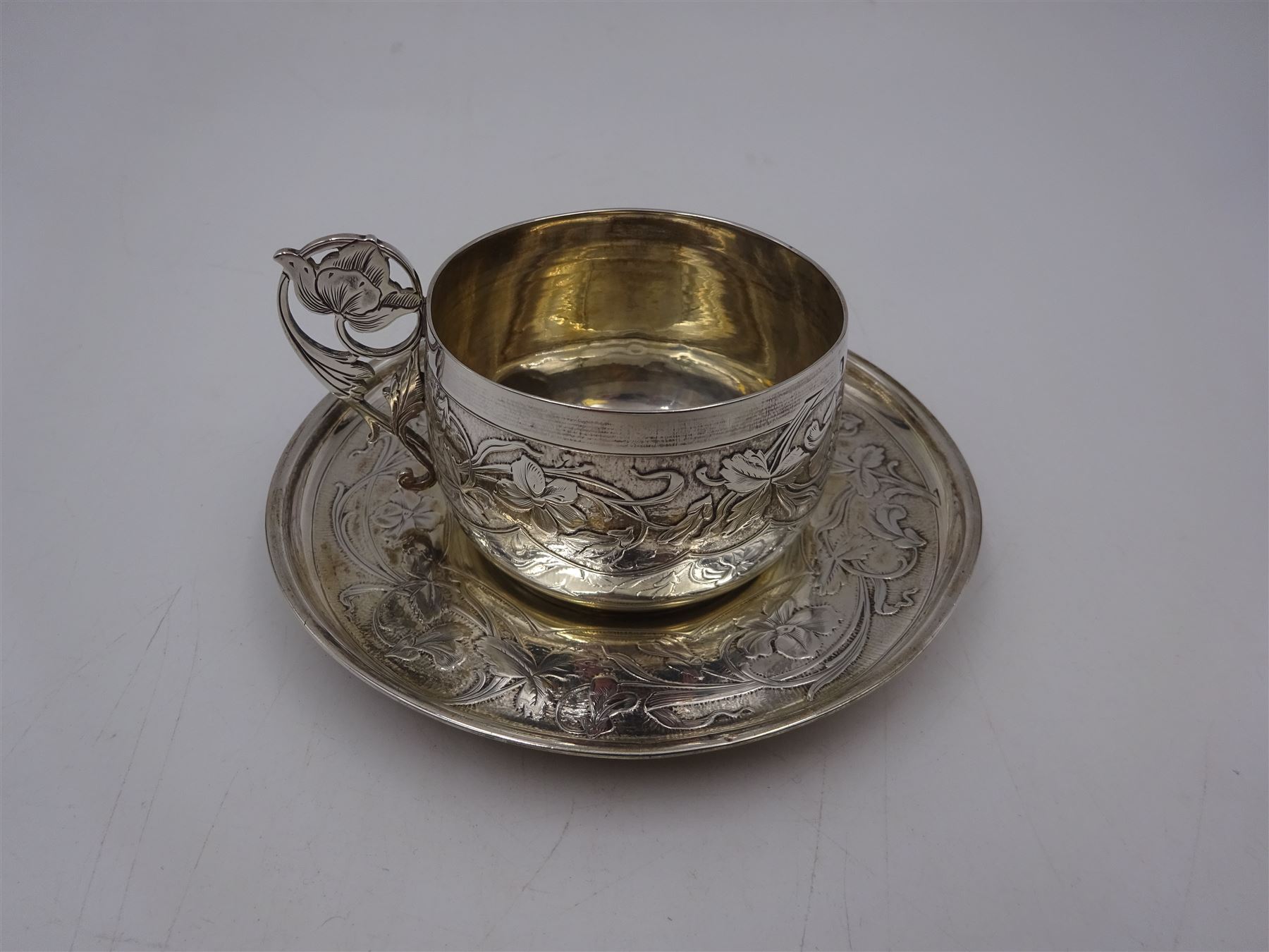 French silver cup and saucer, with embossed floral decoration throughout and openwork floral handle, stamped with Minerva's head and maker's mark for 	P. Fres Paris, cup H5.5cm
