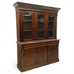 Victorian revival hardwood dresser, projecting moulded cornice above three glazed doors enclosing shelves, moulded top over three drawers and three panelled cupboard doors, flanked by applied carved scroll brackets, on plinth base,