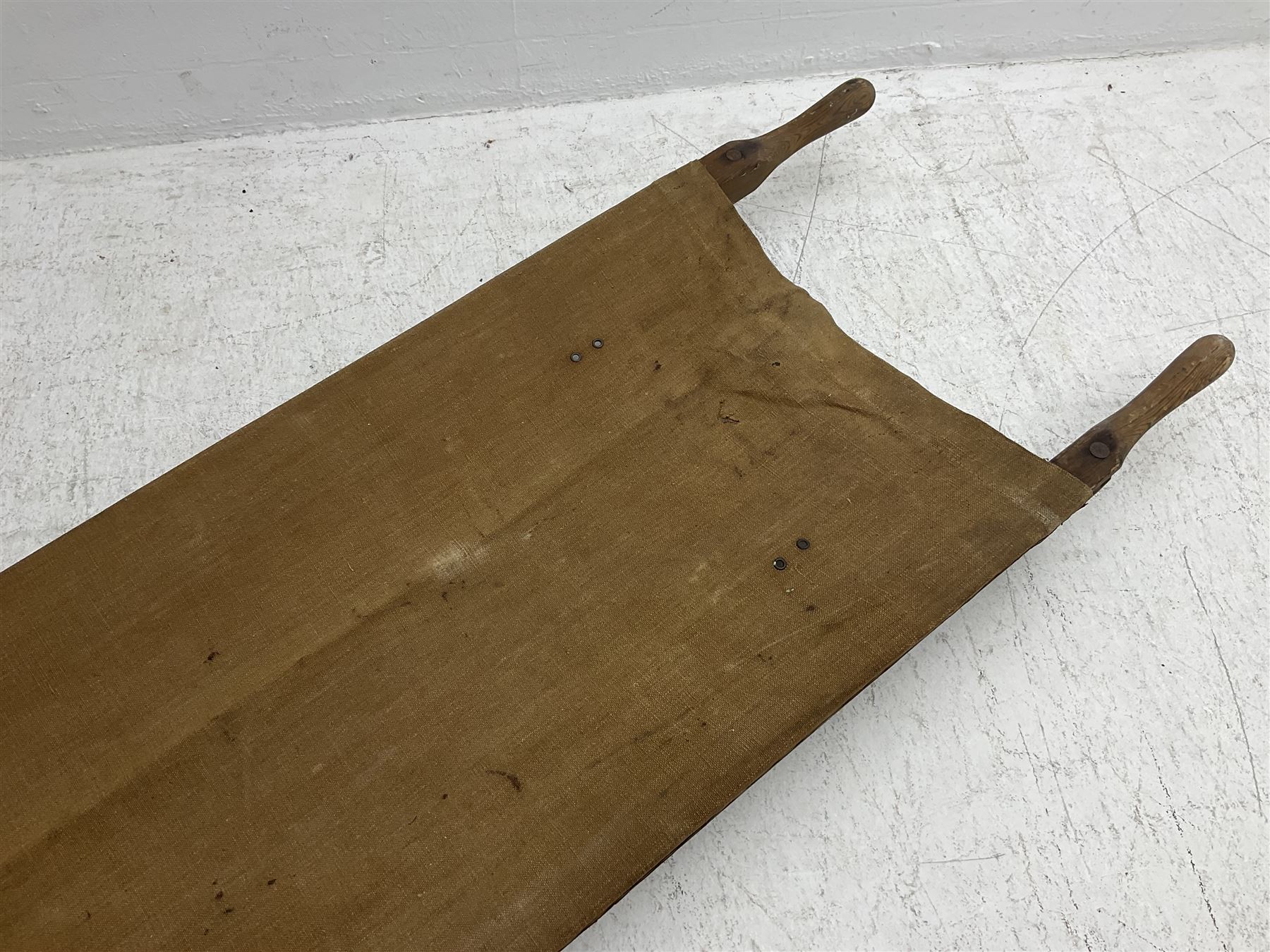 WW1 British casualty stretcher with iron mounted pitch pine sides and canvas base; stamped 'HL1917' and L7 with broad arrow in a triangle L236cm ( reputedly recovered from a barn at Bapaume on The Somme)