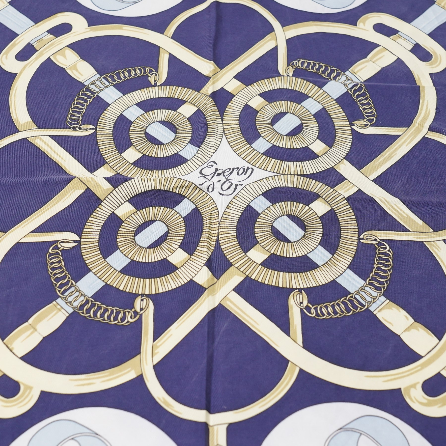 Hermès - ‘Éperon d’Or’ silk scarf, designed by Henri d’Origny, first issued 1974, navy, pale blue, ivory and gold colourway with hand-rolled edges