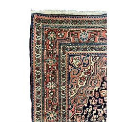 Persian indigo ground rug, the field decorated with intricate interlaced foliage branches and small flower heads, shaped floral design central medallion, the border decorated with scrolling branch and flower heads within guard bands 