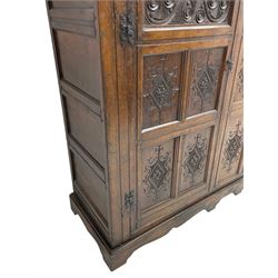 Large 18th century and later oak livery cupboard, projecting moulded and dentil cornice, sunken fillet moulded frame, triple vertical panelled central upright, enclosed by two doors each with five panels, the top row of panels carved with stylised scrolls, the lower panels carved with foliate lozenges, on shaped bracketed skirt base 