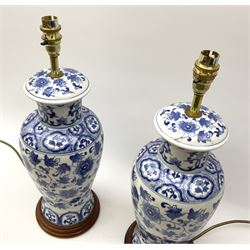 A pair of blue and white Oriental style table lamps, of baluster form with foliate decoration, including fittings H47.5cm.