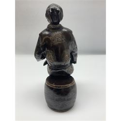 Oriental bronze figure of a gentleman, modelled seated upon barrel with a pipe in one hand and a flask in the other, H21cm