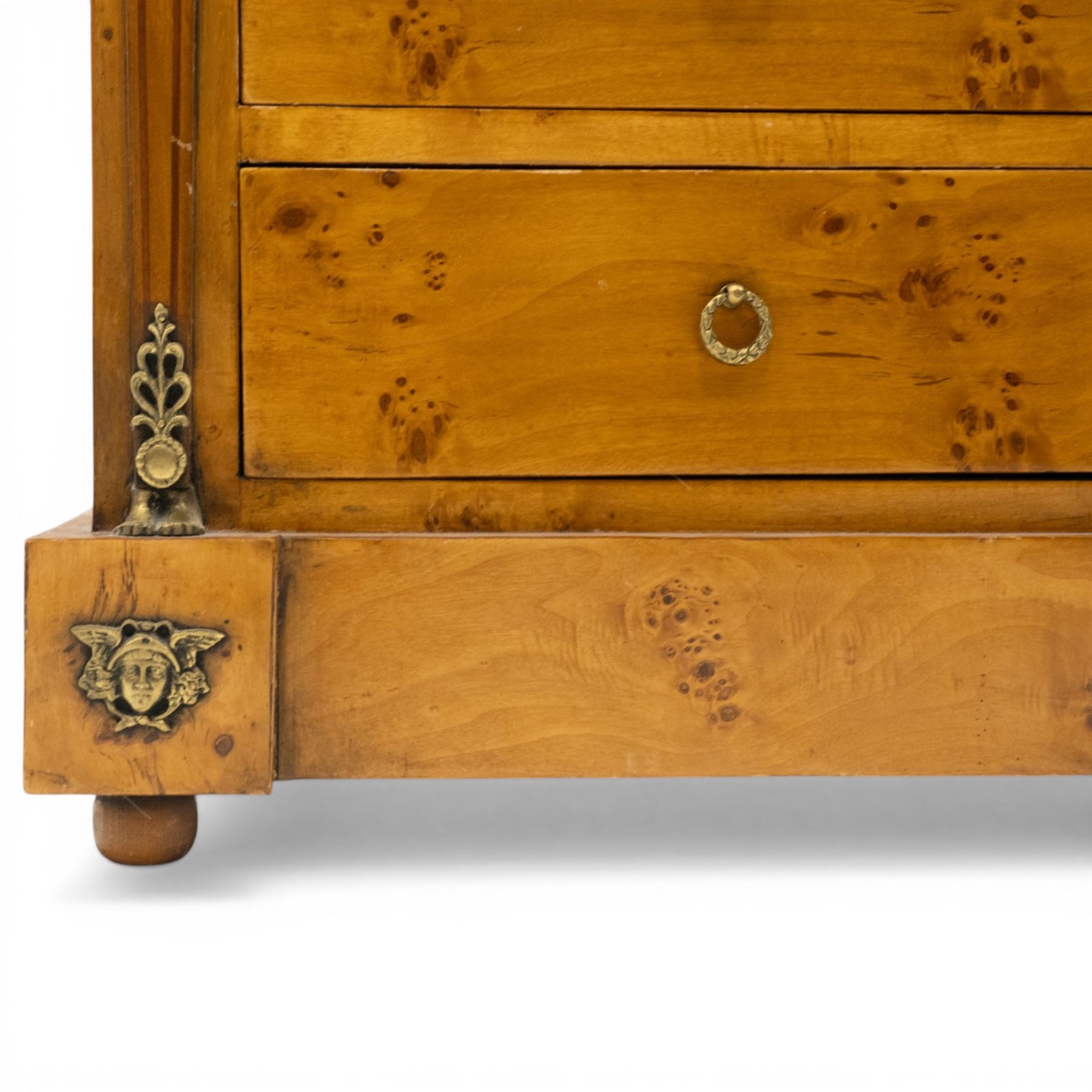 Neoclassical marble and inlaid figured maple wood tall chest, green marble inverted-breakfront top over eight long drawers, flanked by square tapering pilasters with gilt metal female bust and anthemion leaf capitals and brass feet terminals, the skirted base with applied Medusa gilt metal mounts, on compressed bun feet