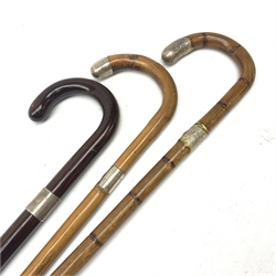 Three silver mounted walking canes, the first hallmarked Kendall & Sons Ltd, London, date letter worn and indistinct, the second hallmarked Birmingham 1924, maker's mark C&S, the third marked Sterling Silver, C&S. 