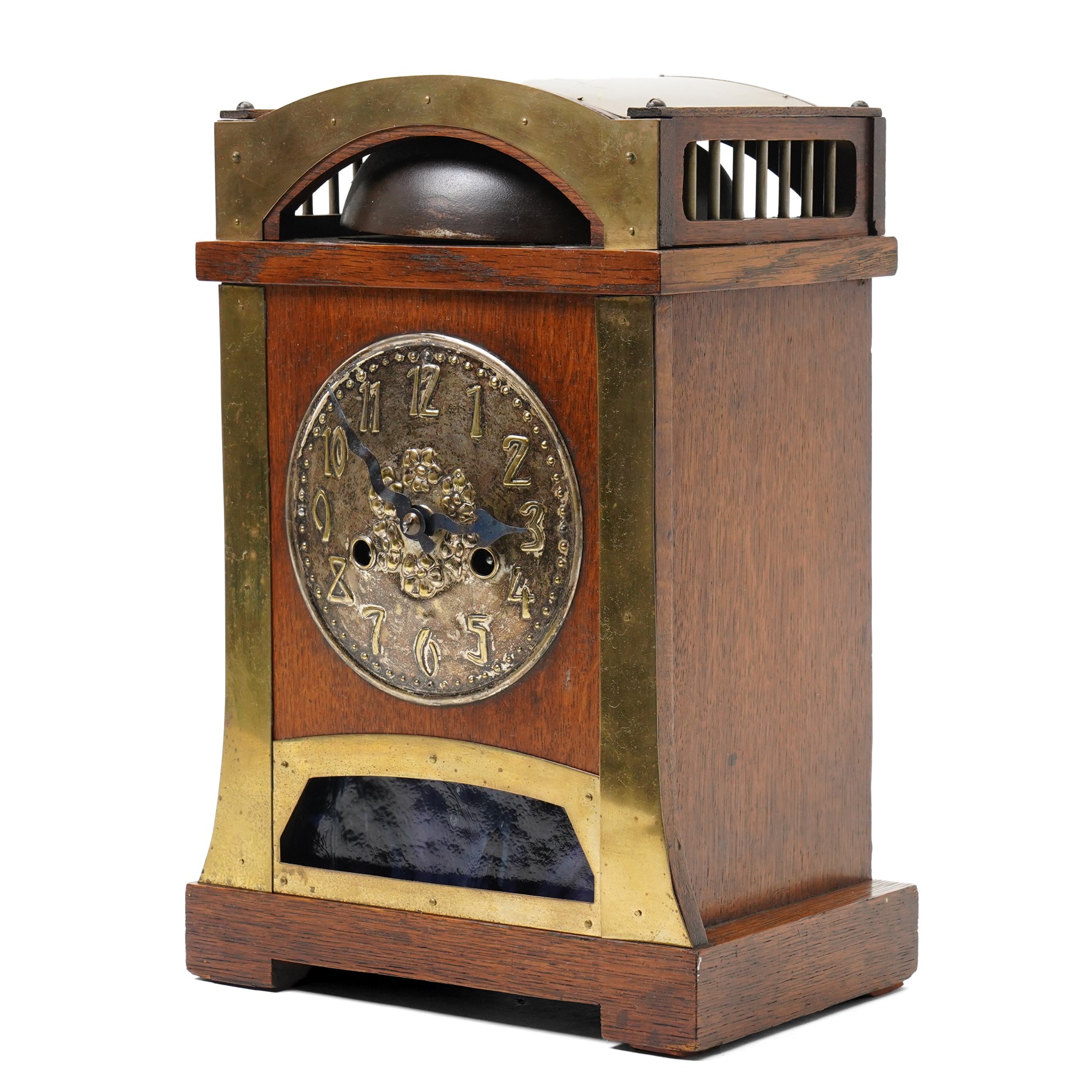 Arts and Crafts oak and brass mounted mantel clock, Hamburg-American Clock Company (HAC), for Liberty & Co, the eight day movement with bell strike, repousse dial with Arabic numerals H36.5cm

  