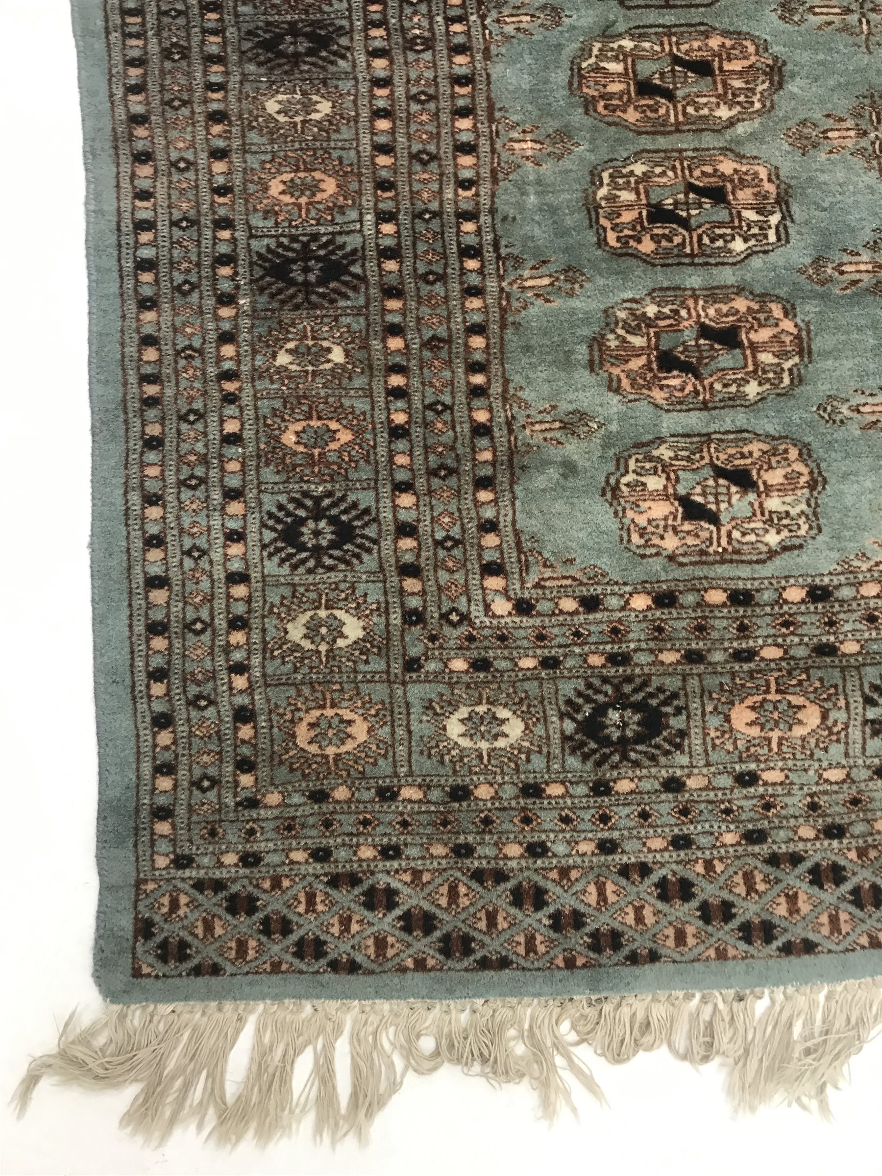 Bokhara green ground rug, geometric patterned field, repeating border