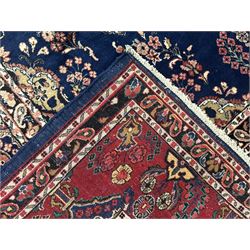 Persian Herati design indigo and red ground carpet, decorated with floral motifs, arched border
