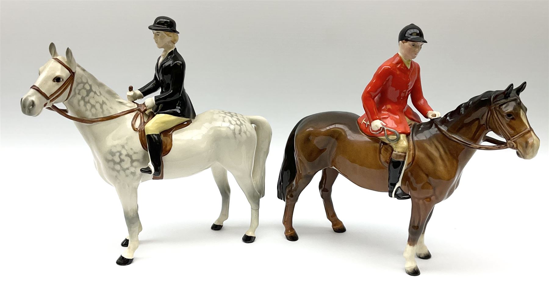 Beswick model of a huntswoman on grey horse model no 1730, and Beswick huntsman on brown horse model no 1501, both with printed mark beneath. 