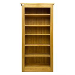 Contemporary light oak open bookcase, rectangular form with projecting top, fitted with five adjustable shelves, on a straight plinth base