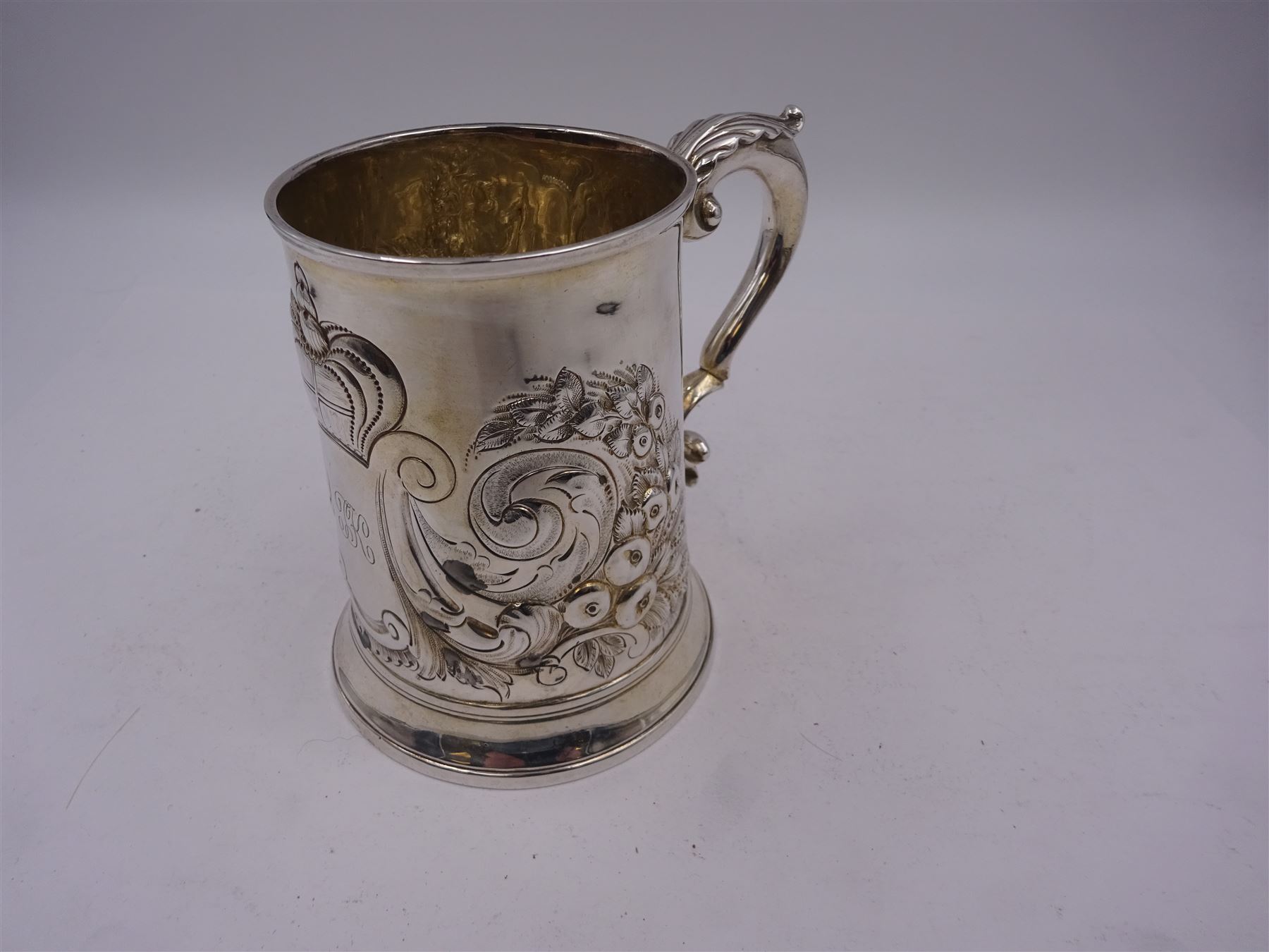 George III silver tankard, of slightly tapering cylindrical from, with chased and repousse crown above a monogrammed cartouche and floral, foliate and C scroll decoration, with acanthus capped C scroll handle, hallmarked WT, possibly William Turton, London 1774, H11.5cm