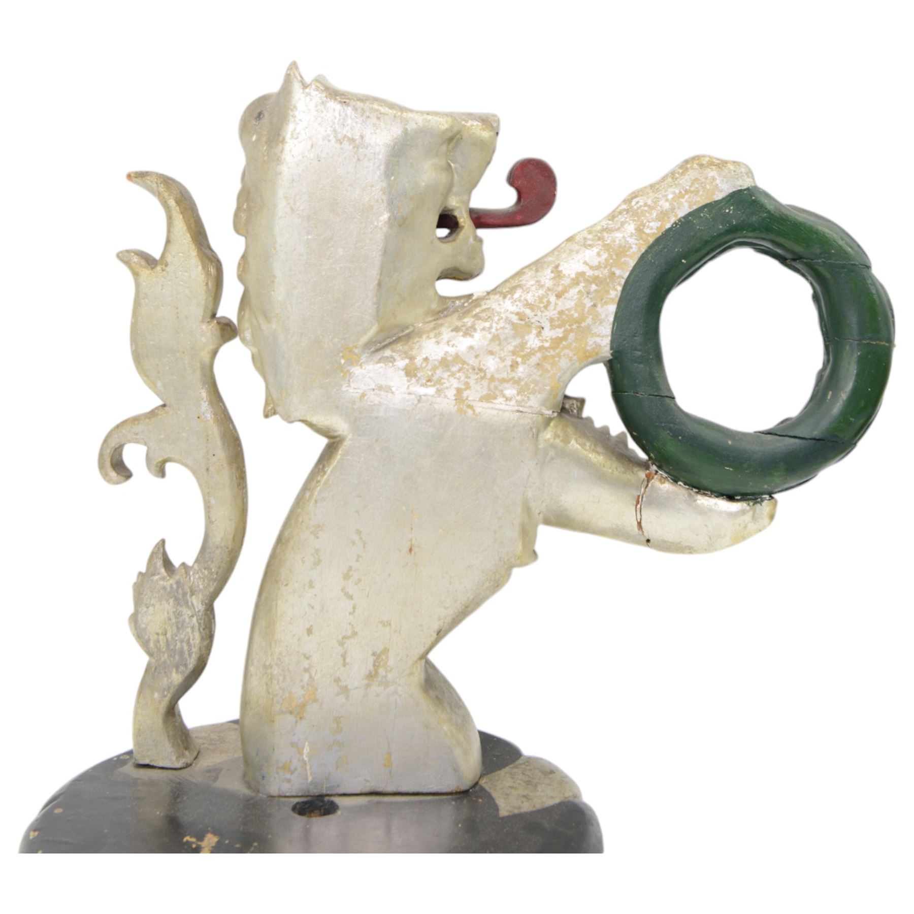 20th century carved silvered wood crest of a lion holding a wreath, possibly a horse tether, on circular wooden plinth, H37cm 