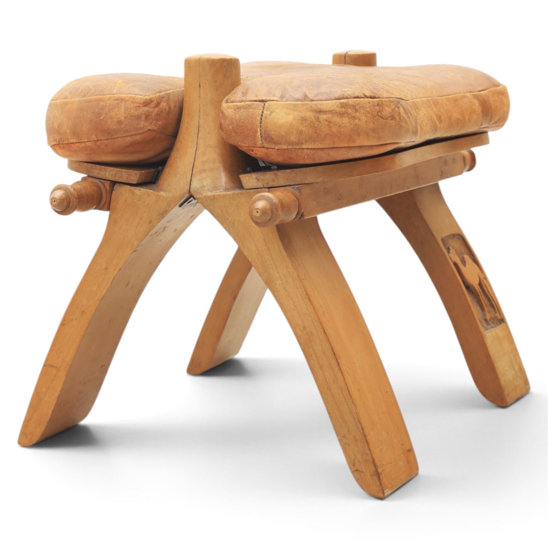 20th century Camel stool, tan leather seat with tooled design, raised on a light wood carved frame with camel design