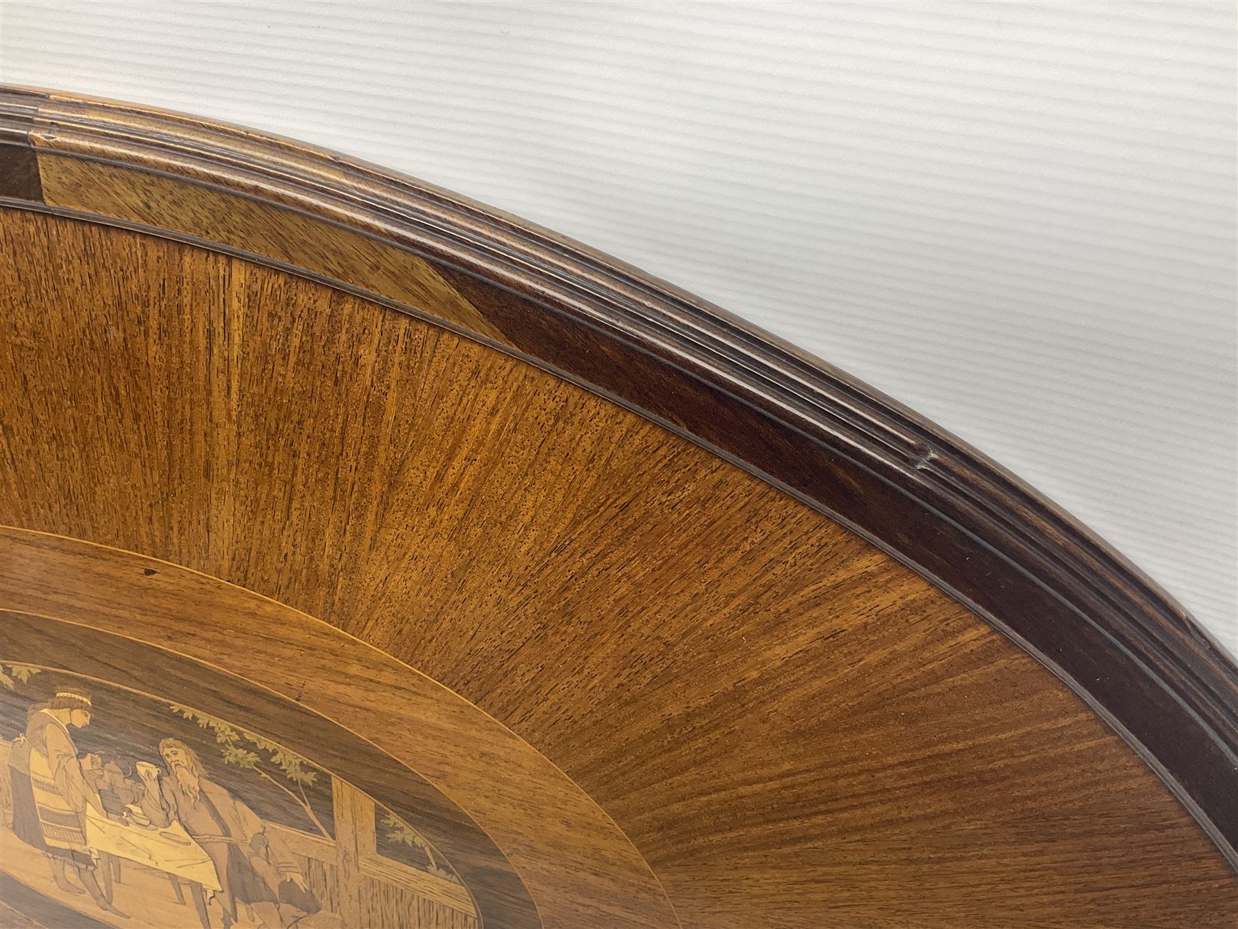 Late 19th/early 20th century mahogany and marquetry inlaid tray, of oval form with twin scrolled handles and moulded border, the central panel inlaid with figures seated at a table drinking tea, L99cm