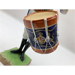 Dresden Drummer of the 3rd Guards figure, modelled playing drum standing to attention, his dress and headwear detailed with gilt, raised upon green and brown square plinth base, with printed marks beneath, H27cm