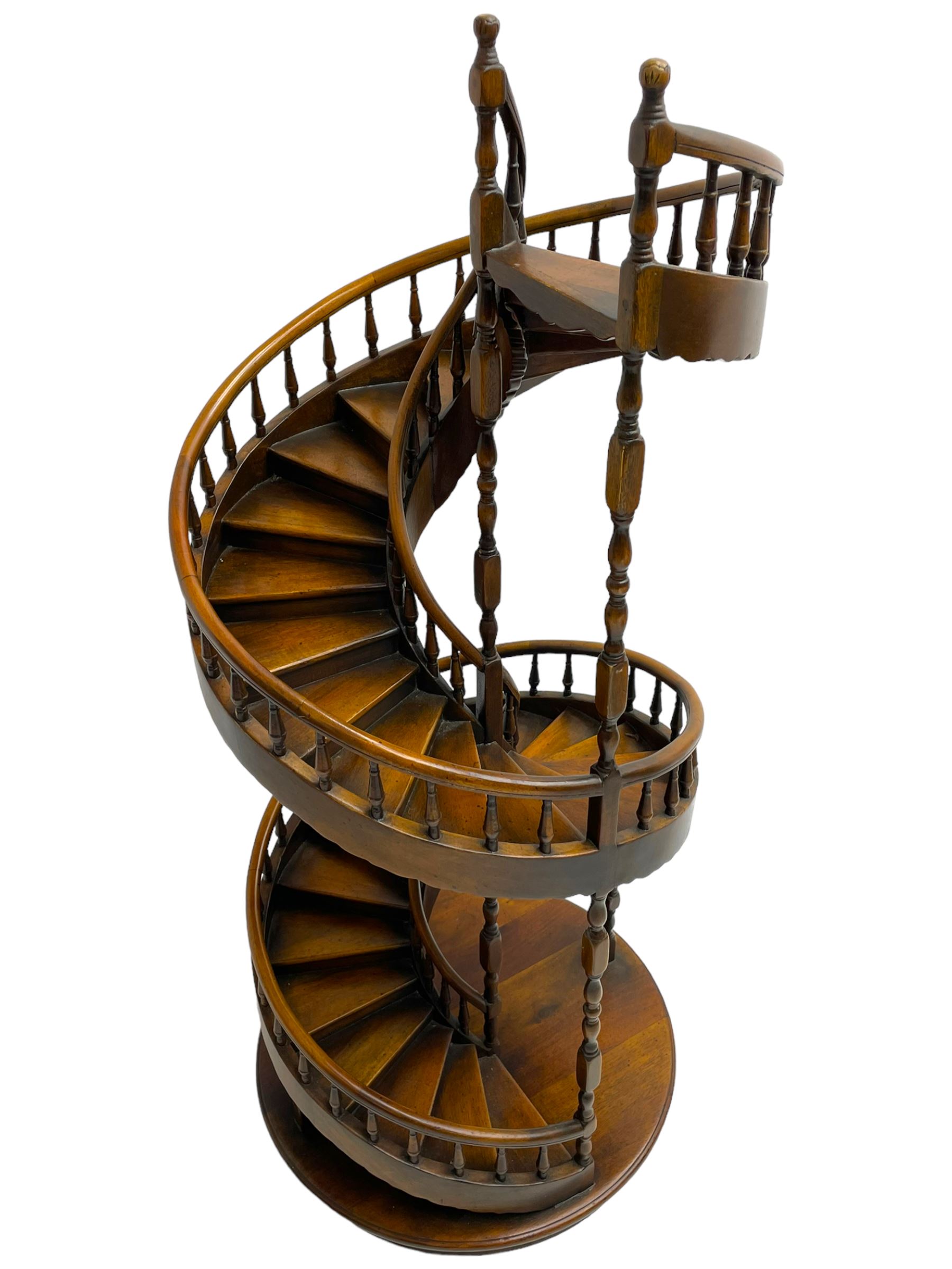 Miniature fruitwood spiral staircase, turned newel posts and balusters, rounded handrail, on circular moulded base