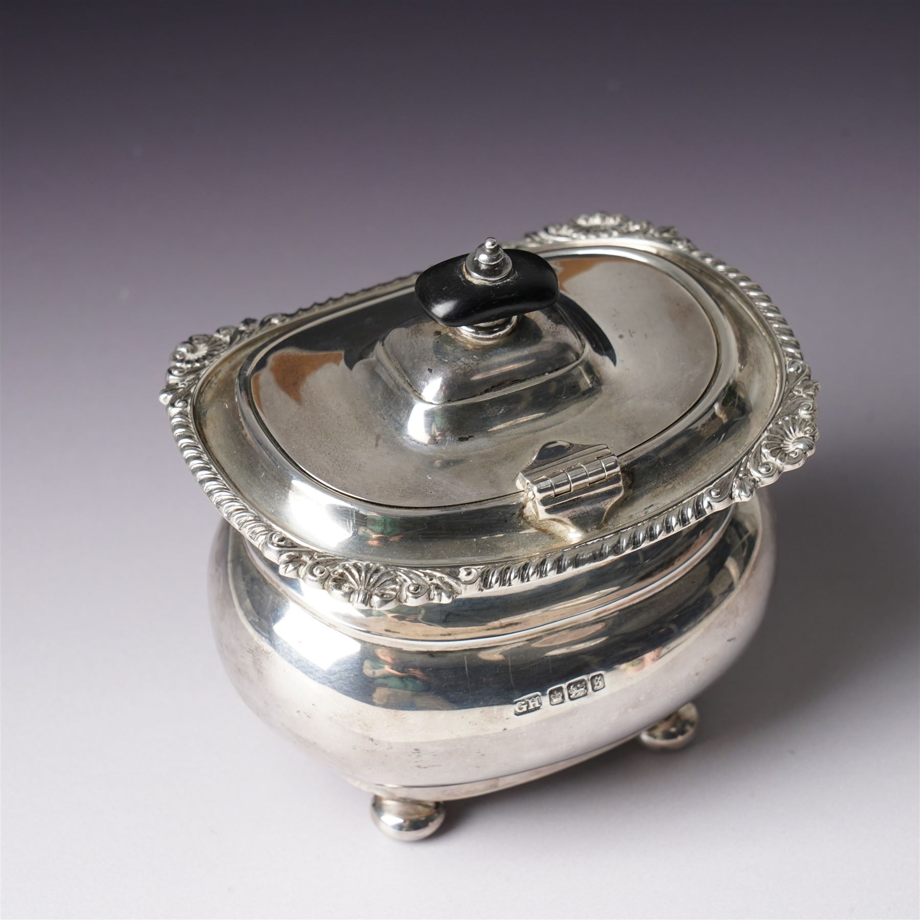 Edwardian silver tea caddy with hinged lid, ebonised lift and gadrooned edge on compressed bun feet Sheffield 1910 Maker Harrison Bros. and Howson