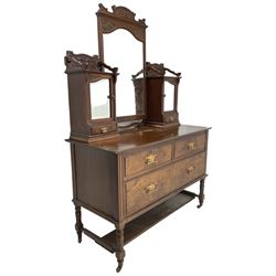 Late Victorian walnut dressing table, raised mirror back with foliate carved pediment and bevelled plate, flanked by raised cupboard with mirror doors over trinket drawers, base fitted with two short over one long drawer, on turned supports with castors