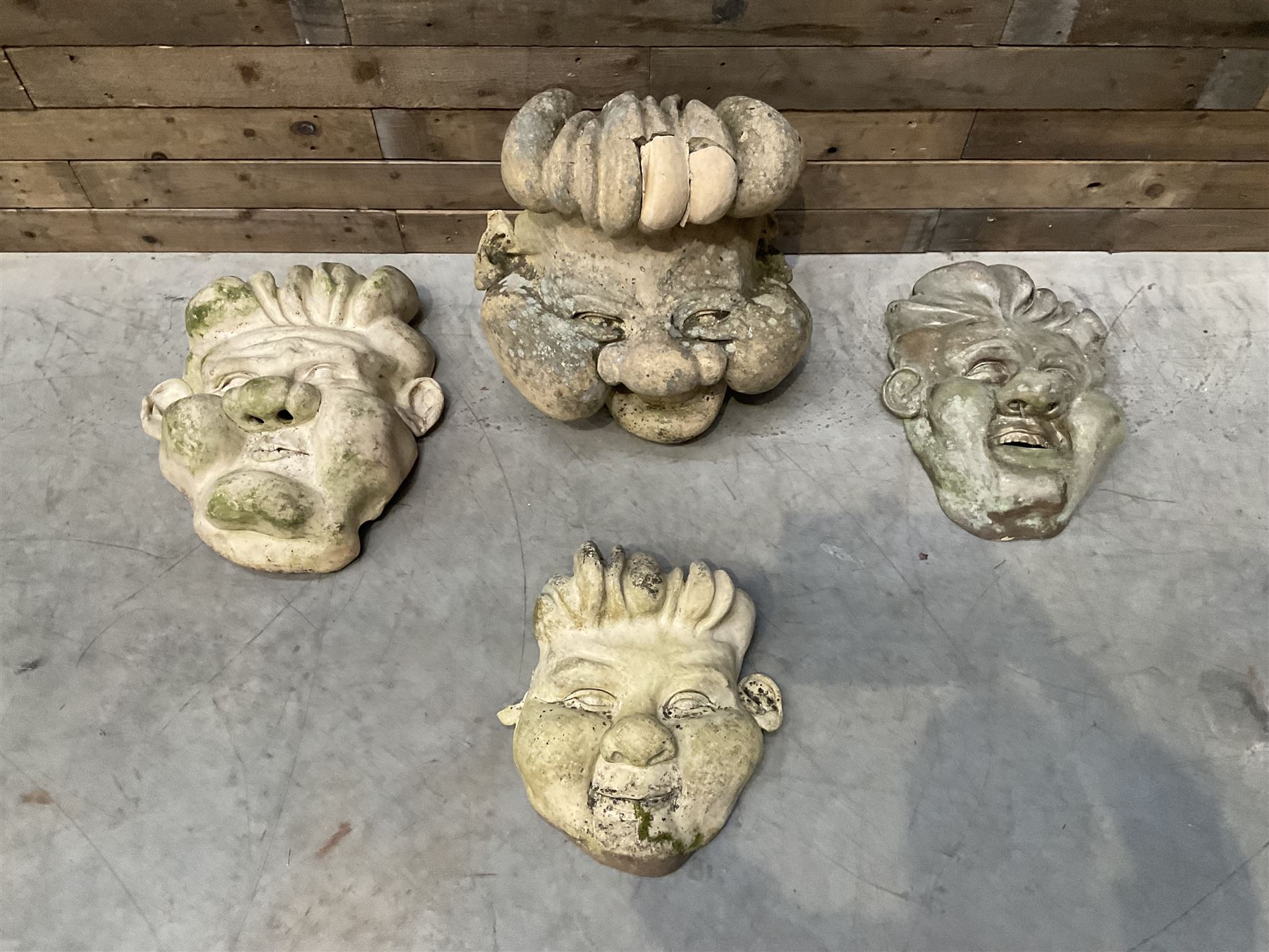 Four grotesque garden wall masks