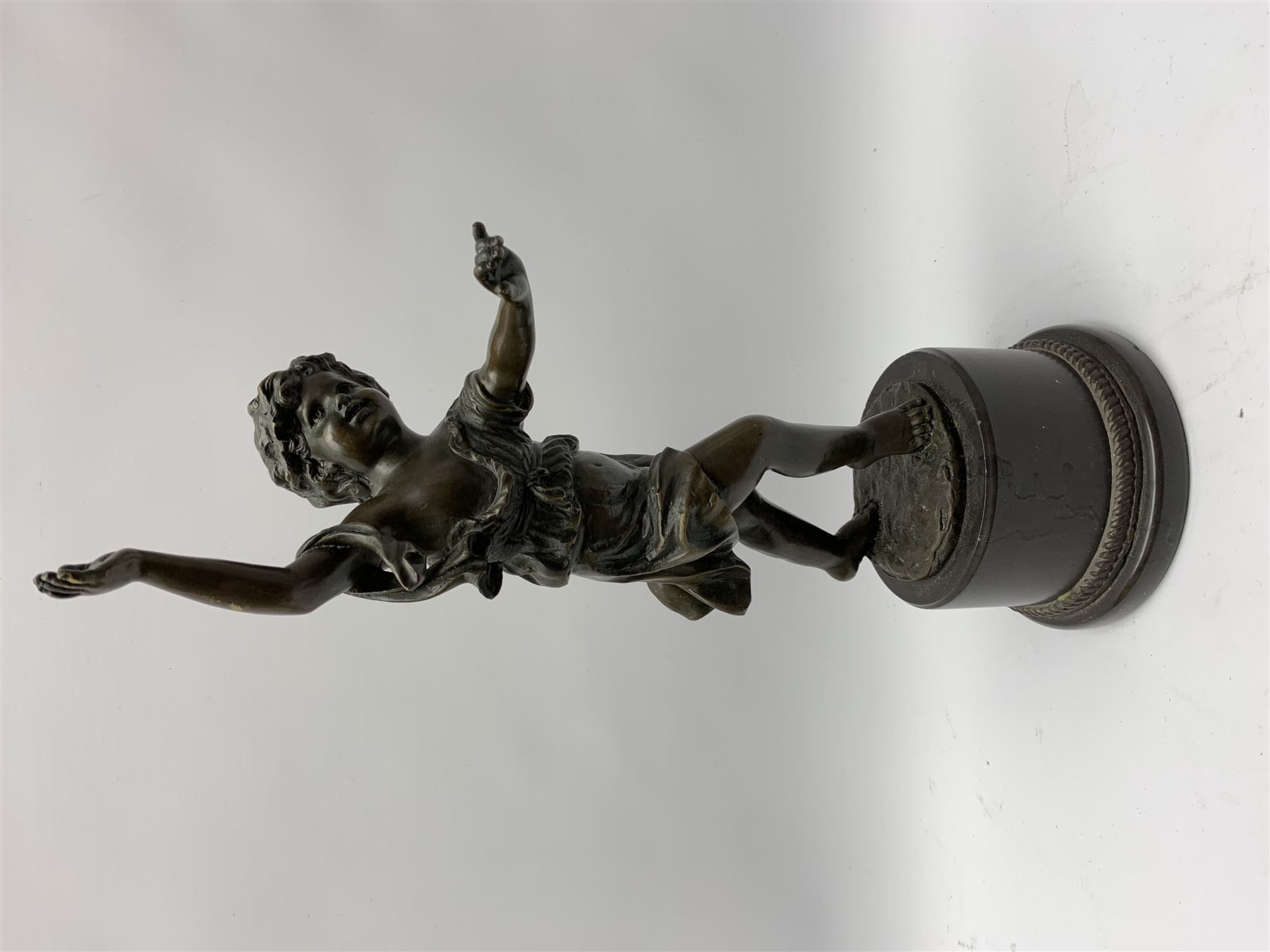 After E Plat, bronze modelled as a dancing child, signed E. Plat, upon cylindrical black marble base, H40cm