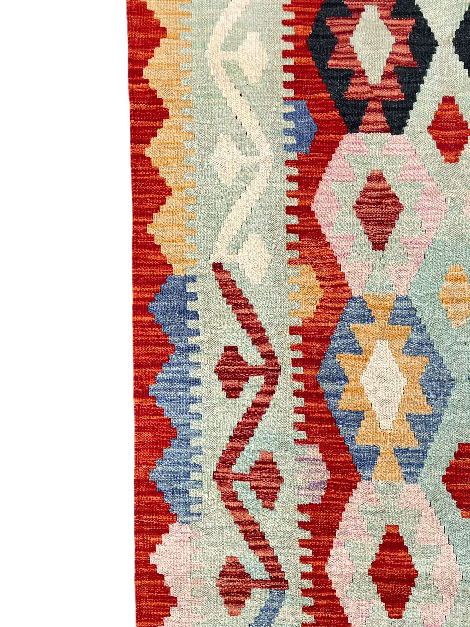 Large Kilim carpet, overall geometric design, decorated with lozenges within a tailing border, geometric guard stripes 