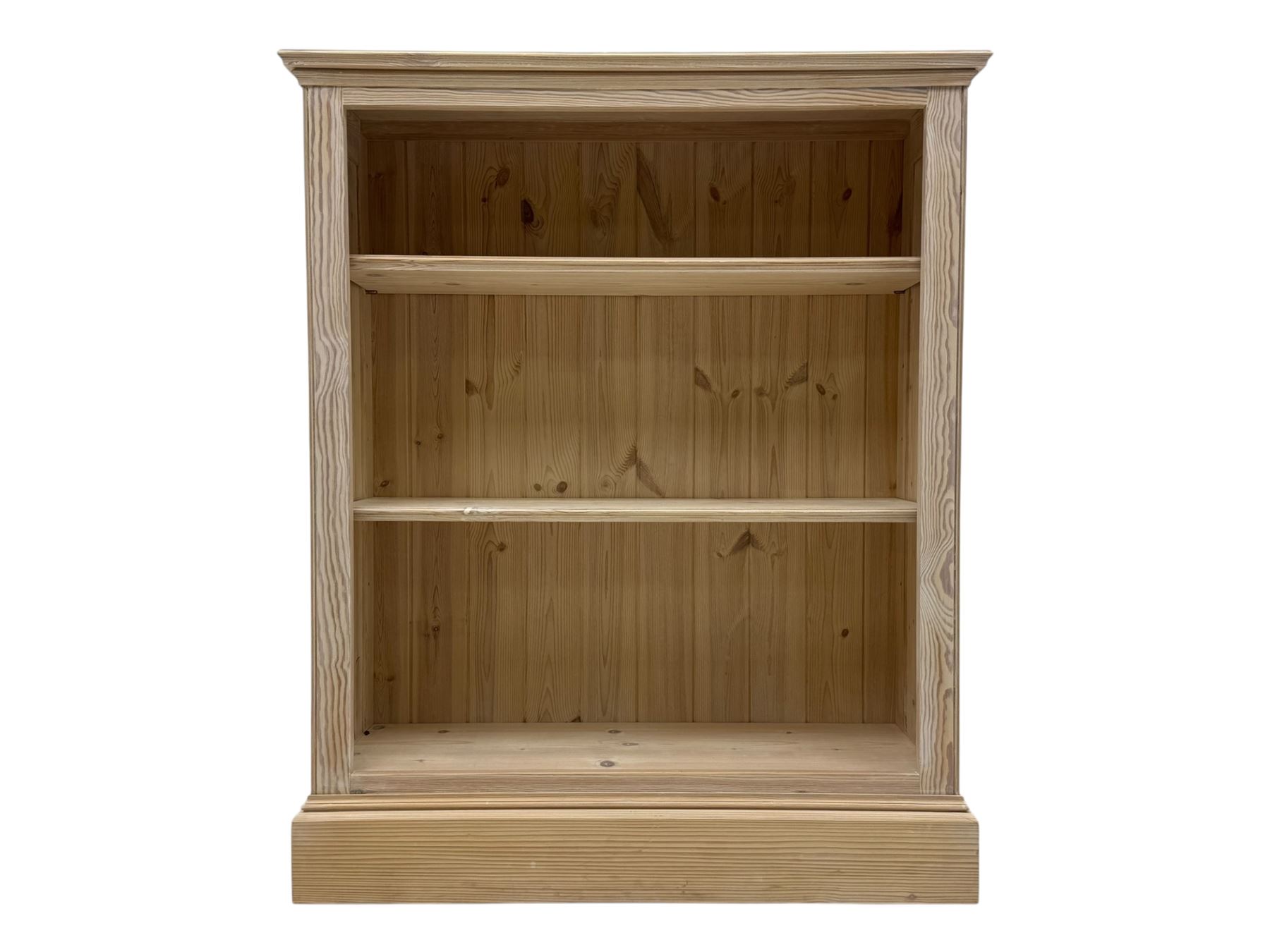 Contemporary light pine open bookcase, rectangular top with stepped moulded edge above a boarded back, fitted with two adjustable shelves, on a plinth base