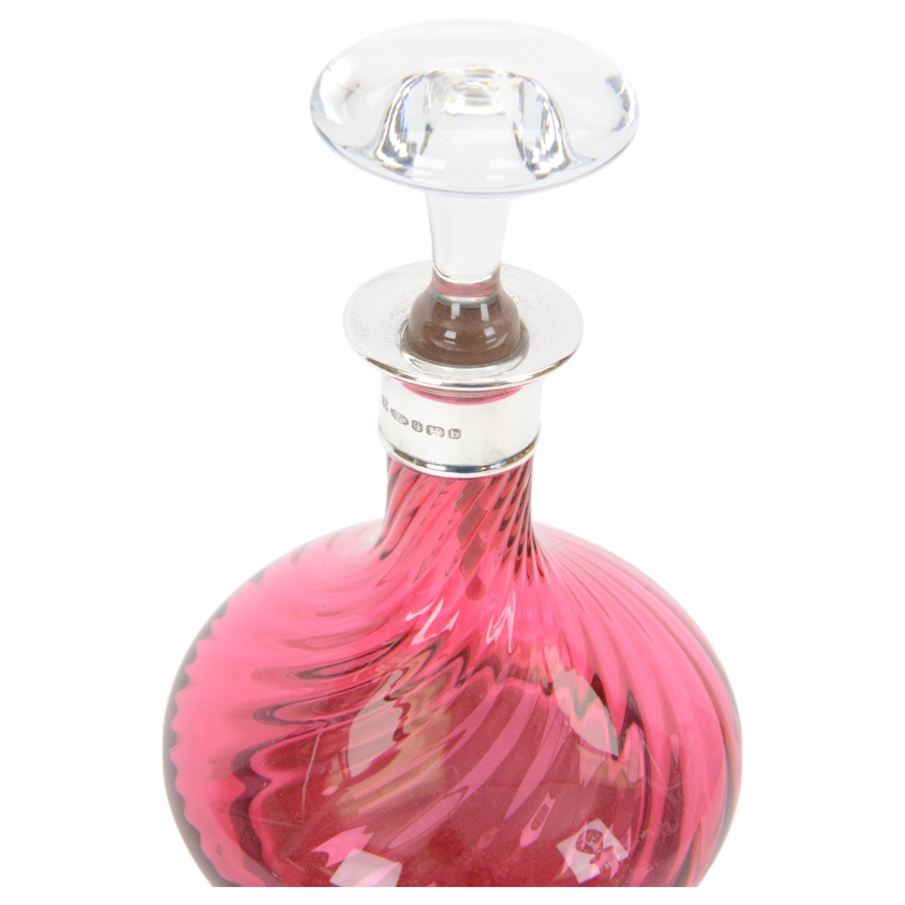 Two modern silver mounted glass decanters, the first a cranberry glass example, with fluted body, clear stopper and silver collar, hallmarked Barker Brothers Silver Ltd, Birmingham 2001, together with a clear cut glass example with silver collar, with import marks for London 1985, tallest H25.5cm