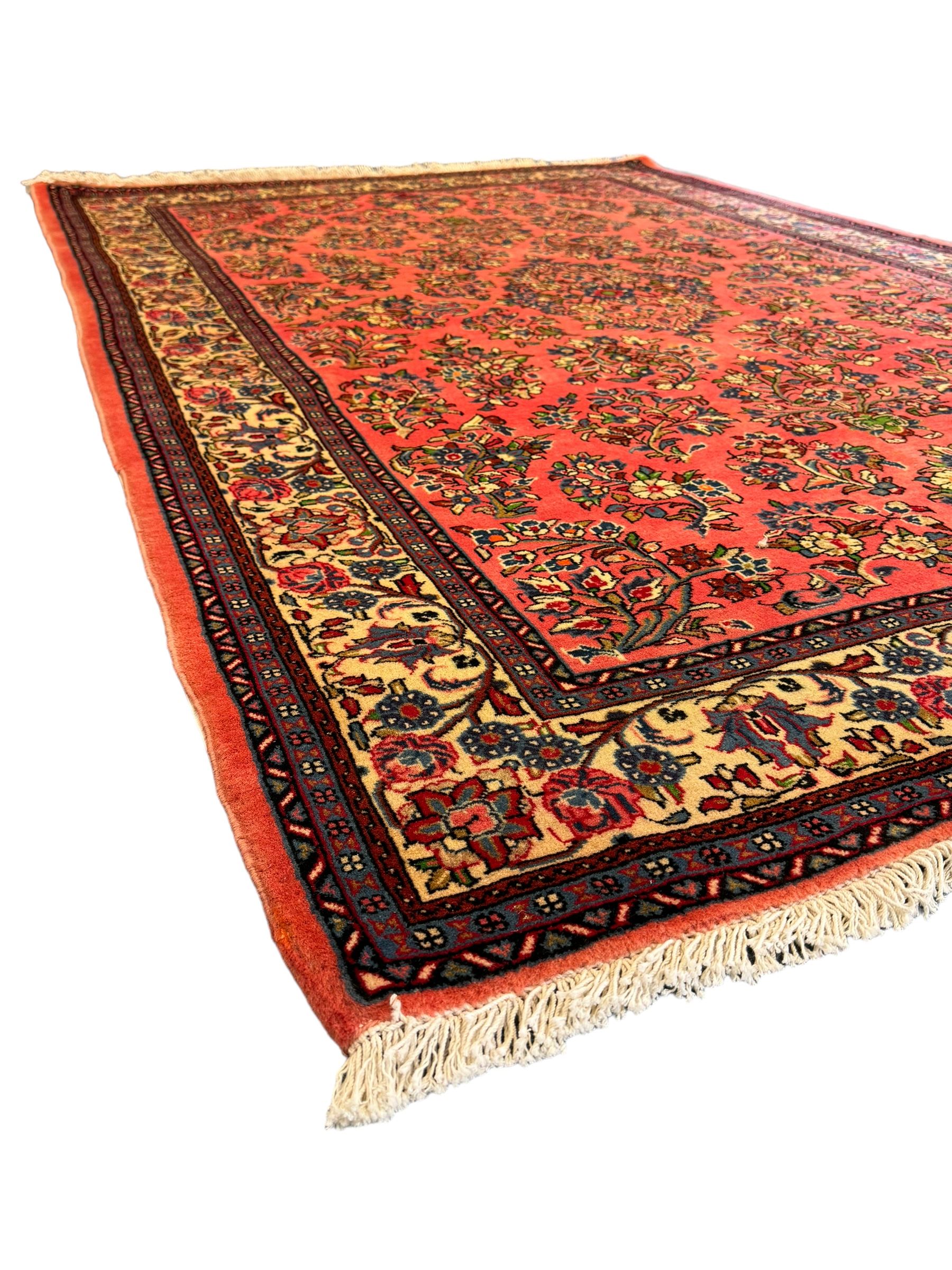 North West Persian Sarouk peach ground rug, the field decorated with floral bunches, pale ground border with repeating flower head motifs within guard stripes 