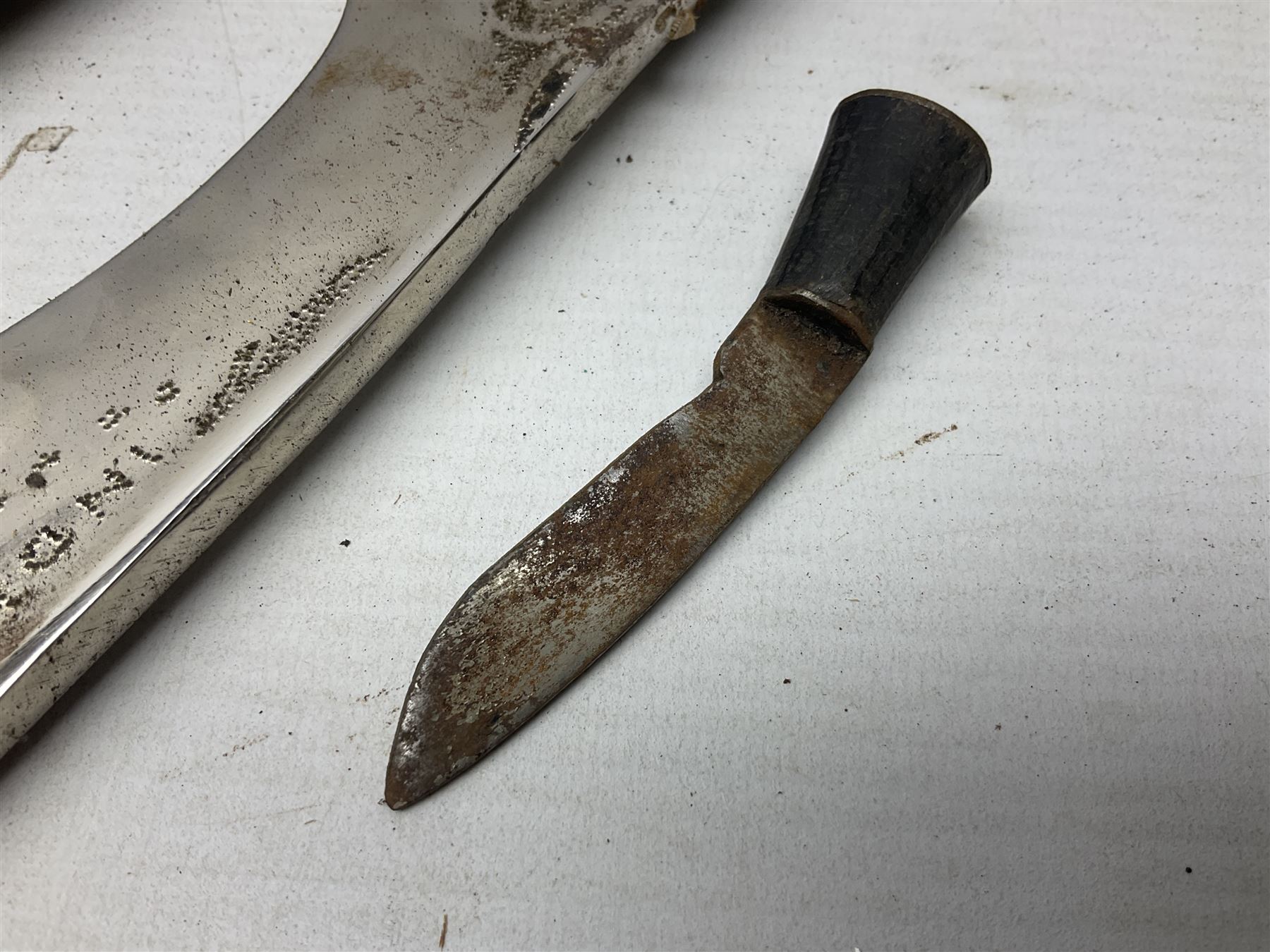 Indian kukri with 29cm curving steel blade and nickel mounted horn grip; in leather covered scabbard with one skinning knife L42cm overall; Hitler Youth knife with scabbard in relic condition; and three African graduated knives each with crudely carved wooden grips and painted leather covered scabbards (5)