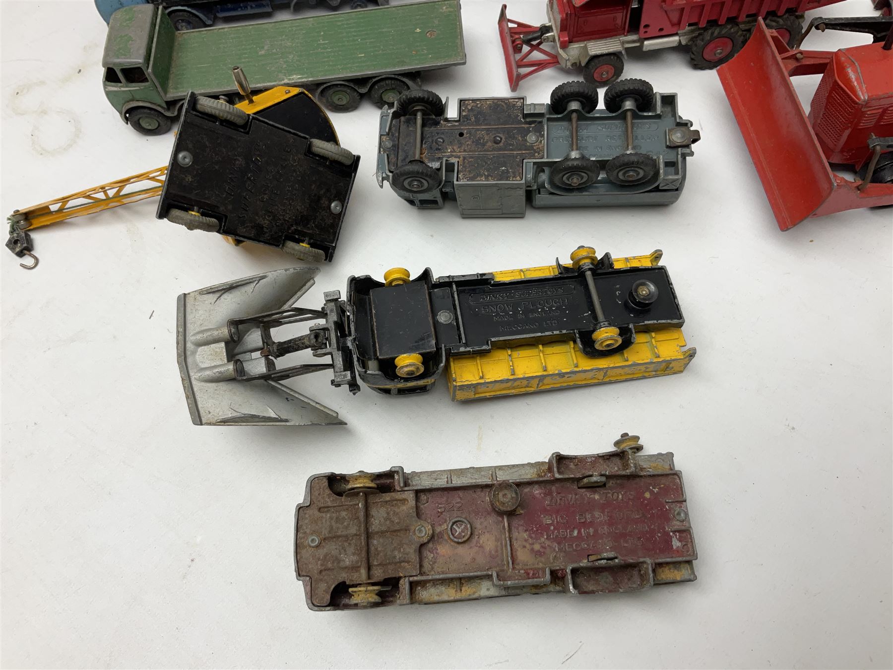 Dinky - twenty-six unboxed and playworn die-cast models including Foden Regent Tanker, two Foden lorries, Pressure Refueller No.642, Snow Plough, Elevator Loader, Foden Dump Truck, Blaw Knox Bulldozer and other commercial vehicles