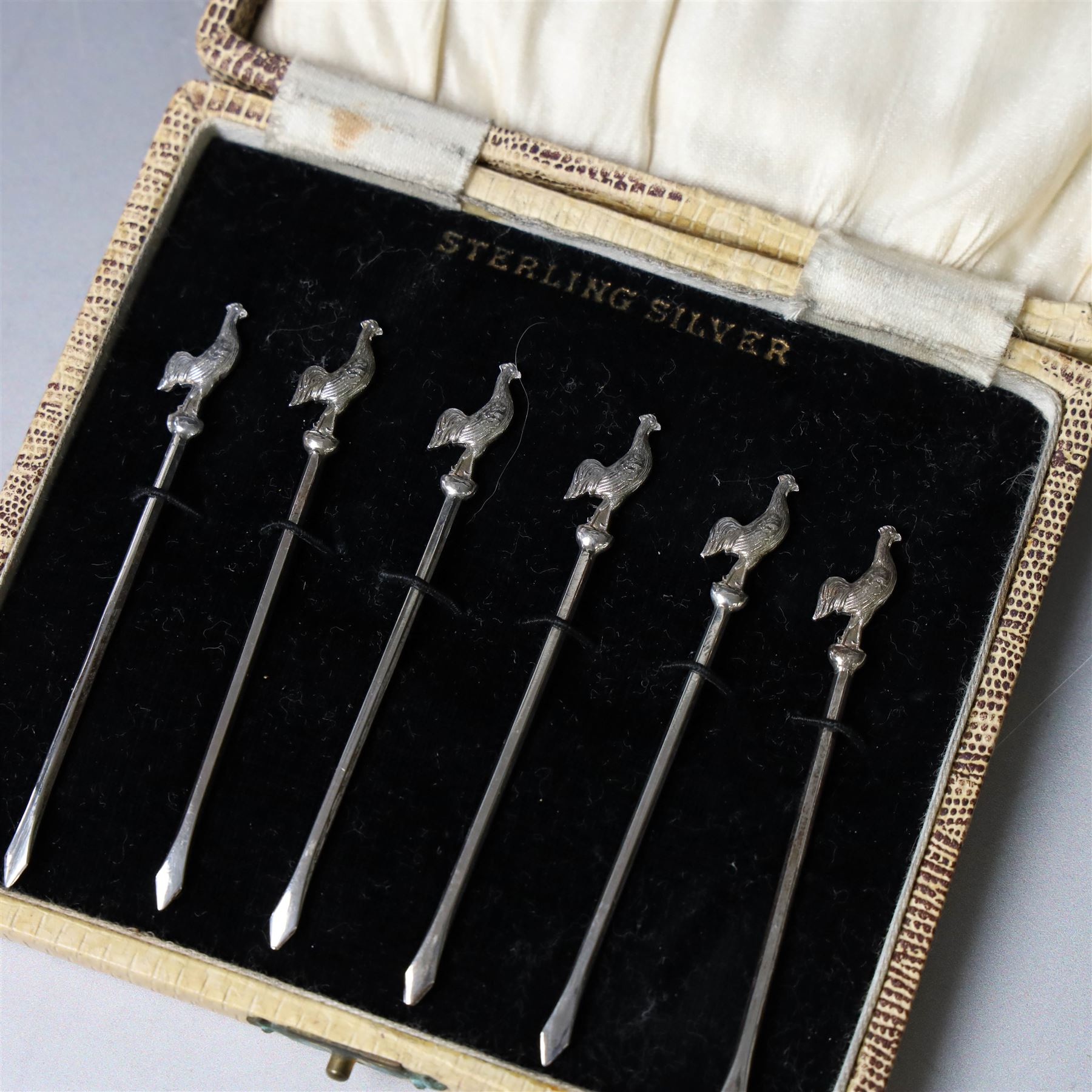 Set of six silver cocktail sticks, each with cockerel finials, stamped Sterling Silver, in fitted case