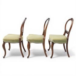 Victorian mahogany dining suite, oval tilt top dining table raised on a quatriform base with paw feet, together with a set of six balloon back dining chairs with green upholstery with cabriole legs 