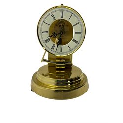  A late 20th century -  German Kieninger & Obergfell, “Kundo” battery operated
mantle clock under an acrylic shade, with an electrically operated solenoid pendulum housed on a circular brass base, skeleton movement with visible motion work through a painted 4-1/2” open chapter ring, with pierced steel hands, Roman numerals and minute track.